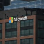 A tall building with a microsoft logo on top of it